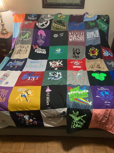 Customer's large Premium T Shirt Quilt made of colorful running shirts, displayed flat on a bed.