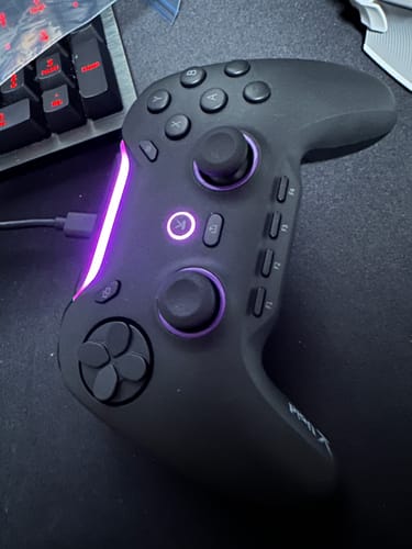 レビューアーのVoid GENESISコントローラー。机の上に置かれ、紫色のLEDが光っています。