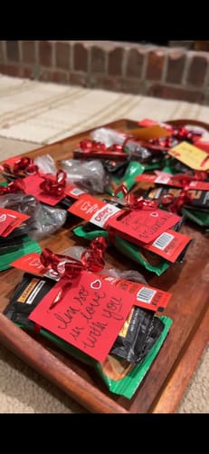 Customer's SuperCharged Honey packs on a tray, decorated as Valentine's gifts with red bows and handwritten cards.