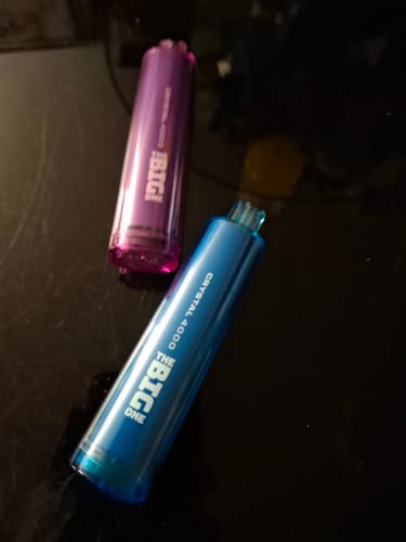 Customer's two elegant Big One Crystal 4000 vapes, one blue and one purple, on a dark surface.