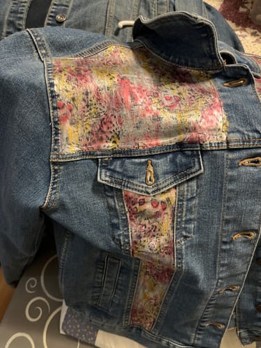 A reviewer's blue denim jacket with colorful, custom-painted panels on the front and shoulders.