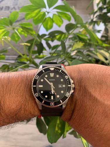 Primer plano del reloj Casio Marlin Duro de un cliente, usado en la muñeca con una planta de fondo.