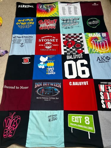 Reviewer's colorful Premium T Shirt Quilt made from various nostalgic t-shirts laid out on the floor.