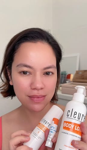 A customer holding a white pump bottle of Body Lotion with other products.