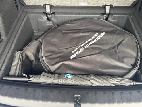Reviewer's Braumach Spare Wheel Kit in its black storage bag, fitting in the trunk of a car.