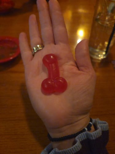 Reviewer holding one large, red Gummy Candy D's in the palm of their hand to show its size.