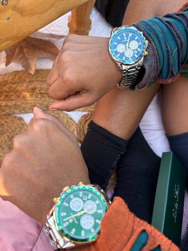 Customer image of two people wearing Lucky Fours® Chronometers, one with a green dial and one with a blue dial.