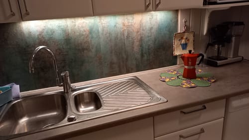 Kundens kjøkken med Oxide steel kontaktplast brukt som en grønn og gyllen sprutvegg.