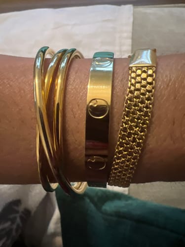 Reviewer's wrist with the elegant Diagonal Cuff Bracelet stacked next to two other gold bracelets.