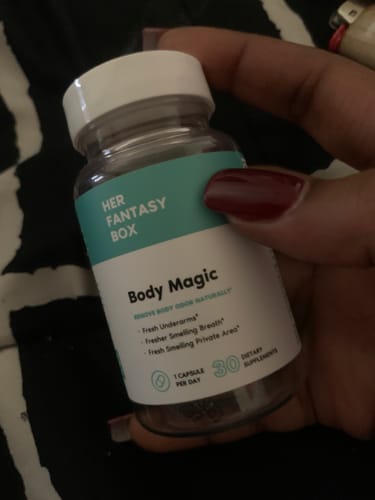 Customer holding a bottle of Body Magic Chlorophyll Pills, showing the teal and white label.