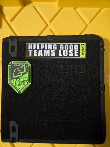 Customer's Helping Good Teams Lose Patch with a lime green border, attached to a black gear bag.
