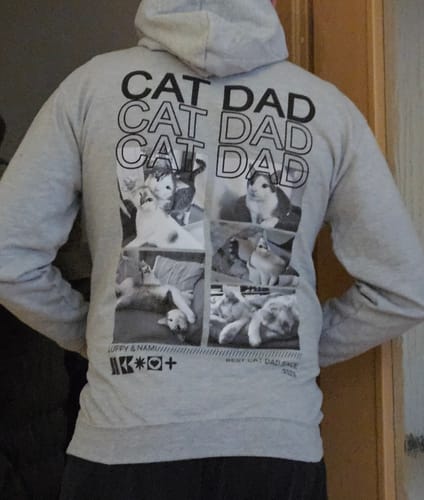 Kunde trägt den grauen „Personalisierter Hoodie - Cat Dad“ und zeigt den großen Fotodruck auf der Rückseite.