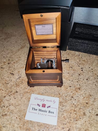 Reviewer's open dark wood Phasmophobia Music Box showing the internal musical mechanism.