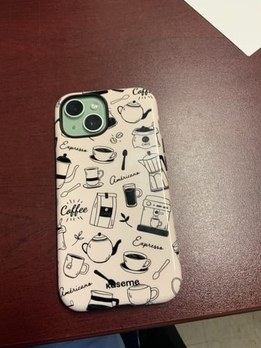 Reviewer's Espresso phone case with a stylish coffee-themed pattern, shown on a phone on a wooden desk.