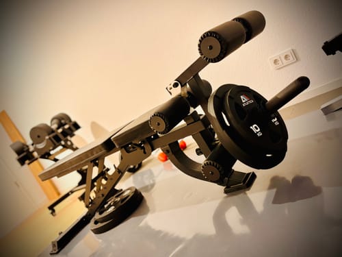 Foto eines Kunden, das die B2 Hantelbank mit der montierten LegMaster Option zeigt, die mit einer Gewichtsscheibe beladen ist.