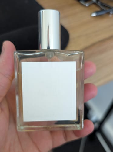 Customer holding the clear, square bottle of Tuxedo Eau De Parfum in their hand.