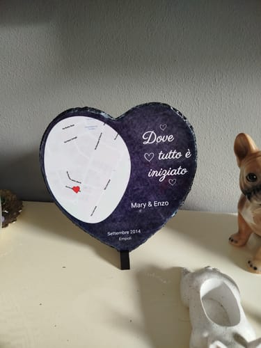 Ein Kunde zeigt sein personalisiertes Schieferherz mit Karte und Text, das auf einem Regal aufgestellt ist.