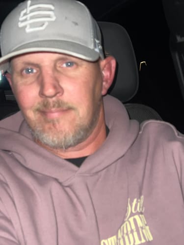 Customer wearing the light grey Subzero Trucker Cap in a close-up photo.