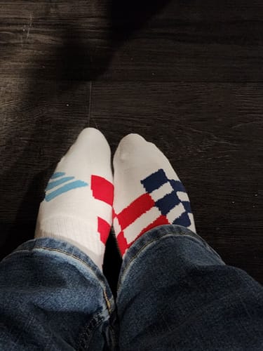 Customer's point of view wearing the white M-POWER SOCKS with colorful block patterns.