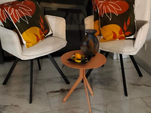 Recensent toont de stevige bijzettafel Daley High in de kleur Clay Terra in een woonkamer.