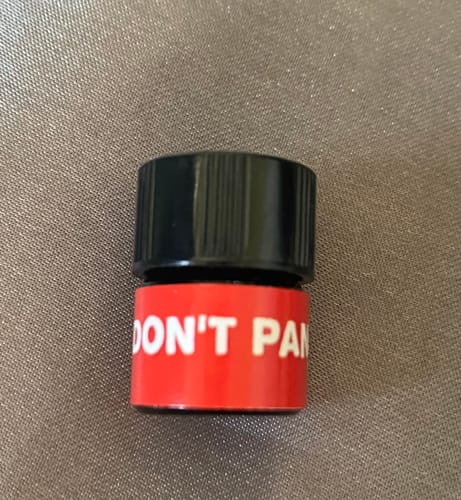 Customer's close-up photo of the small Don't Panic scent bottle with a distinctive red label.