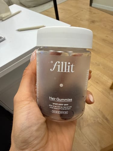 לקוחה מחזיקה בידה צנצנת של סוכריות גומי לשיער.