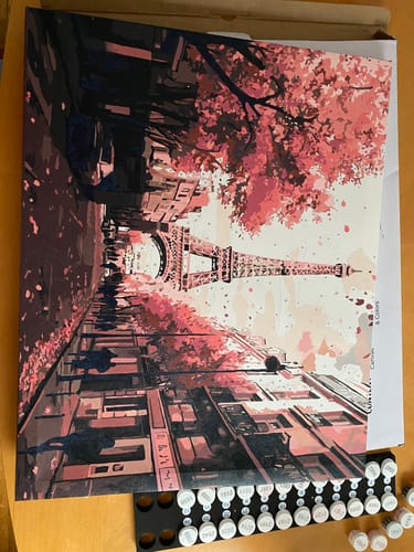 Reviewer's almost-completed 'Beautiful Paris' paint-by-numbers canvas, with the numbered paint pots visible below.