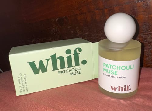 Customer's bottle of Patchouli Muse perfume with a round white cap, displayed next to its green box.