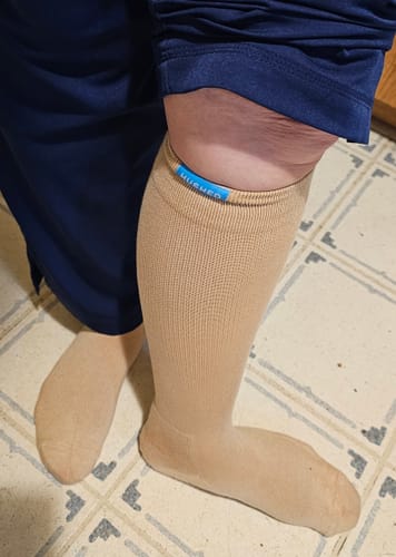 Customer wearing the tan Performance Eucalyptus Compression Socks, showing the knee-high fit on their legs.