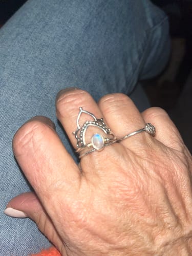 A reviewer's hand wearing the Sterling Silver Boho Ring Set, showing the rainbow moonstone and detailed band.
