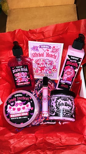 Reviewer's open Monthly Subscription Box with spooky, pastel-colored bath products laid out on bright red tissue paper.