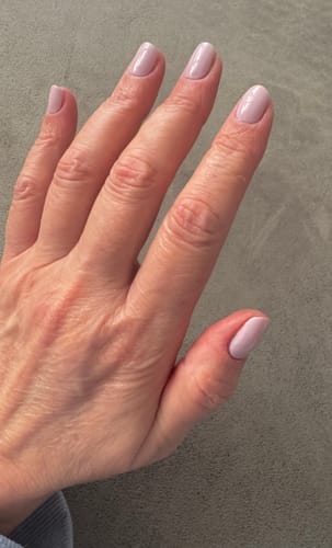 Hand einer rezensierenden Person, die eine schlichte Maniküre mit den einfarbigen Cupcake Icing Nagelfolien trägt.