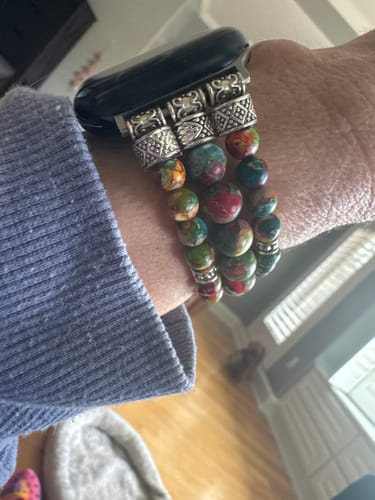 A reviewer's wrist wearing the colorful Vineyard Jasper Stretch Apple Watch Strap with ornate silver connectors.