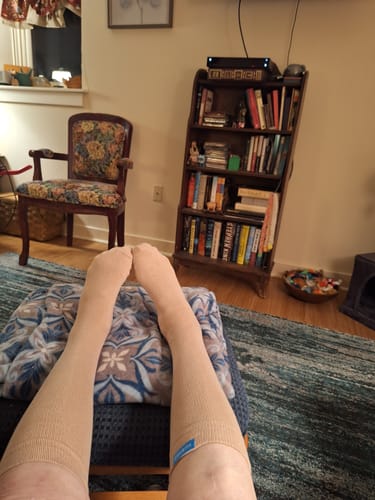 Reviewer relaxing with their feet up, wearing the tan Performance Eucalyptus Compression Socks.