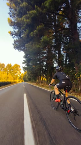 Cliente mostrando el ajuste de la Calza Starlight Z555 mientras pedalea en una carretera.