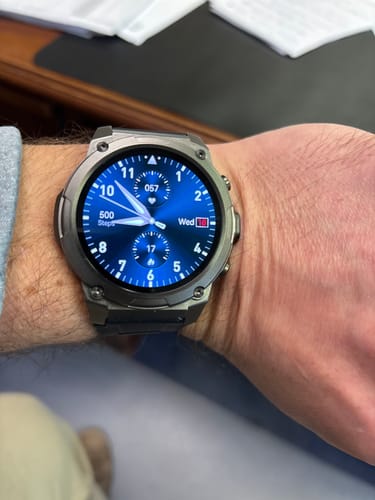 Customer wearing a silver-toned smartwatch with a vibrant blue digital face.