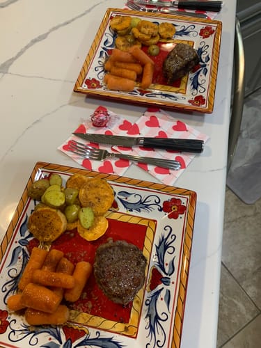 Customer's two plated meals featuring cooked USDA Prime Top Sirloin steaks with carrots and potatoes.