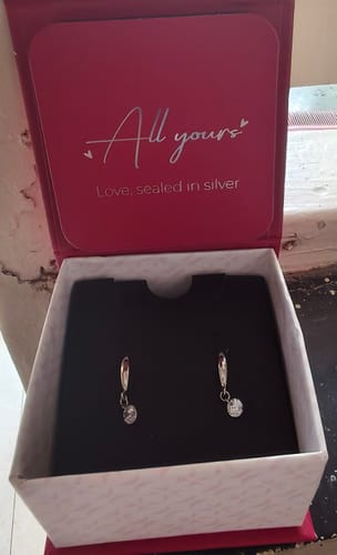 Customer's Silver Classic Shiny Drop Earrings displayed in their opened red and white box.