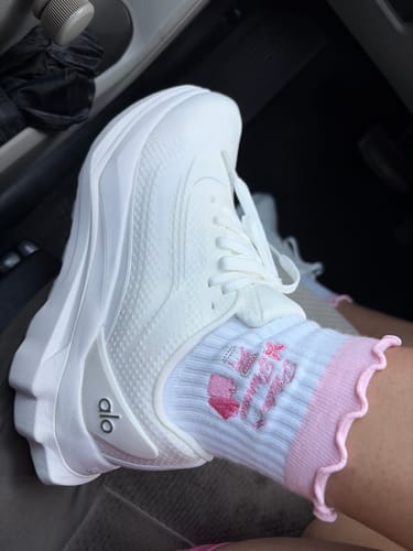 A customer wearing the white Pilates Princess socks with a pink frilly cuff, paired with white platform sneakers.