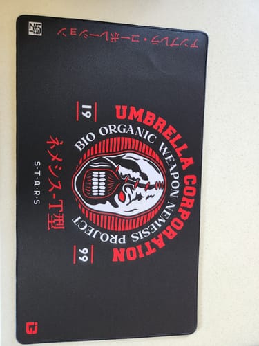 Customer's black Bio Organic Weapon playmat featuring a red and white Umbrella Corporation graphic.