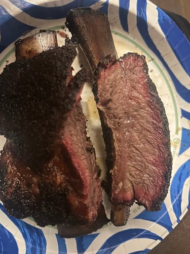Customer's cooked Bone-In Short Ribs cut open on a plate, showing the juicy interior.