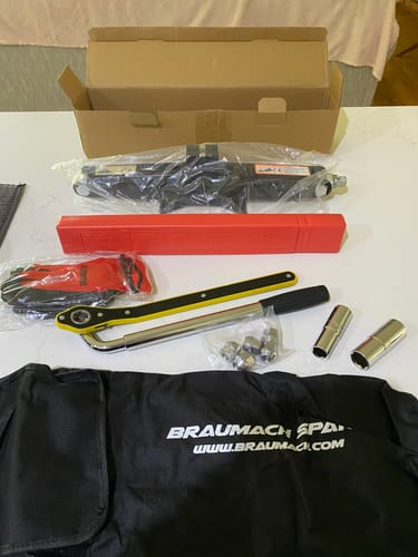 Customer's unboxed KIA EV6 Spare Wheel Kit, showing the jack, wrench, sockets, and storage bag on a countertop.