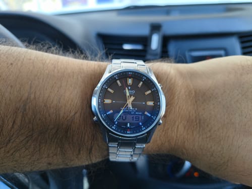 Cliente mostrando su reloj Casio Lineage de acero inoxidable en la muñeca, dentro de un auto.