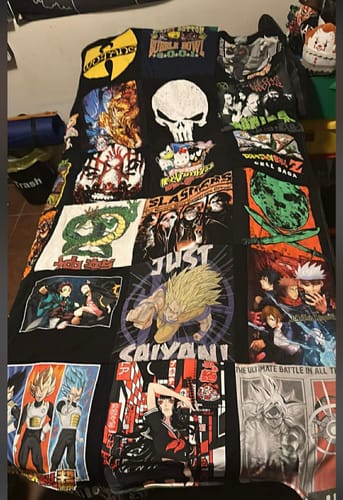 Customer's Premium T Shirt Quilt made from various comic book, anime, and band t-shirts, laid out on a surface.