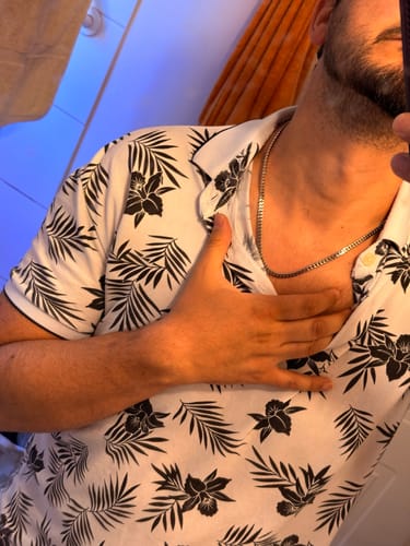 Primer plano de un cliente que lleva la Cadena Miami Cuban de 5 mm sobre una camisa estampada.