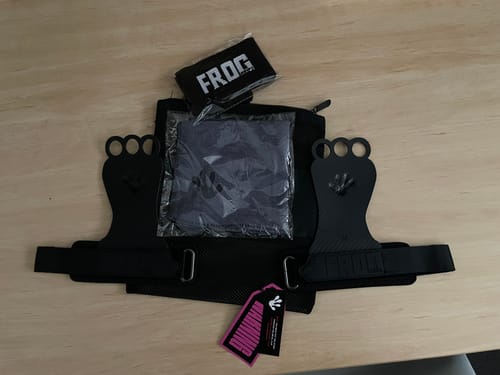 Customer's new black three-hole hand grips shown with wristbands and a carrying bag on a table.