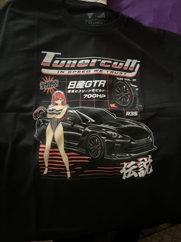 Customer's black t-shirt from the mystery box, showing a large graphic with a sports car and an anime character.