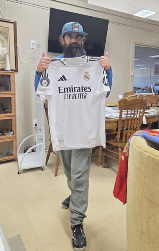 Reviewer holds up a white soccer jersey from the wholesale pack, giving two thumbs up.