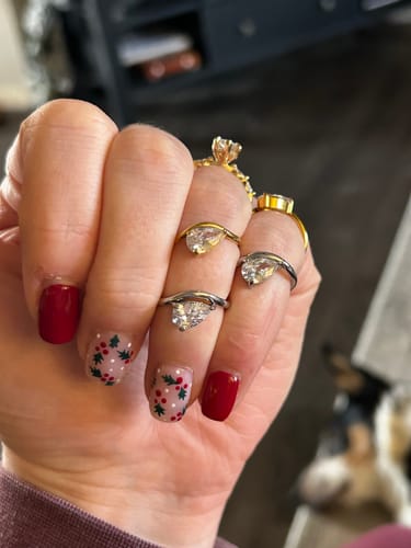 Close-up of a customer's hand wearing two gold and two silver Pia Rings stacked across their fingers.
