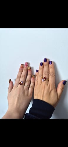 Customer's photo of two hands side-by-side, each wearing a golden Navae Birthstone Ring.